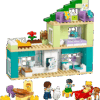 The completed Modern House LEGO set built as a three story luxury beach villa featuring a vertical wood paneled wing large glass windows a swimming pool with beach chairs and two tall palm trees