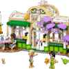The built Plant Cafe and Flower Shop LEGO set showing a tan and green building with purple wisteria flowers a yellow tram car out front and several minidolls tending the gardens