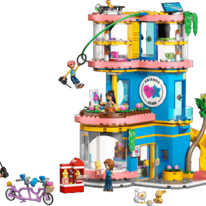 A brightly lit showroom display featuring a completed Friends Clubhouse LEGO set showcasing its tan walls pink roofs and mini dolls playing in the yard
