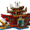 LEGO Baratie Ship One Piece anime exhibition model showing the large brown wooden restaurant hull with a white fish head prow alongside character minifigures on a blue ocean base