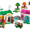 A completed Creative Houses LEGO build configured as a rustic summer cottage with a dark red roof yellow front door stone chimney exterior fireplace a small blue pond and a brick built yard tree