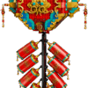 The front view of the built Fortune Firecracker LEGO set showing a large red ornate diamond medallion with gold accents hanging above eight red cylindrical firecrackers with golden tassels