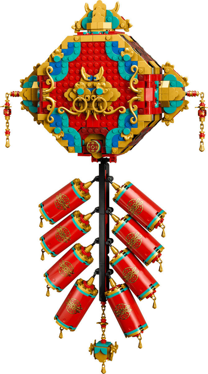 The front view of the built Fortune Firecracker LEGO set showing a large red ornate diamond medallion with gold accents hanging above eight red cylindrical firecrackers with golden tassels